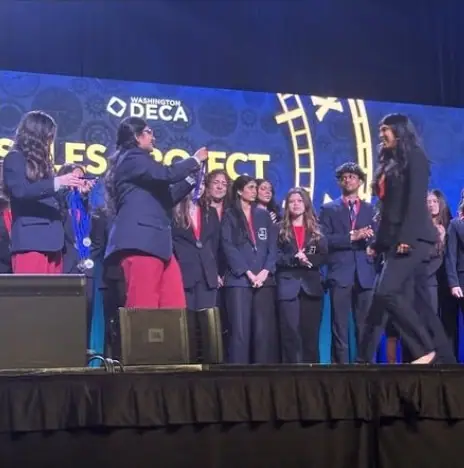 Students receiving medals on stage at the Washington DECA state competition